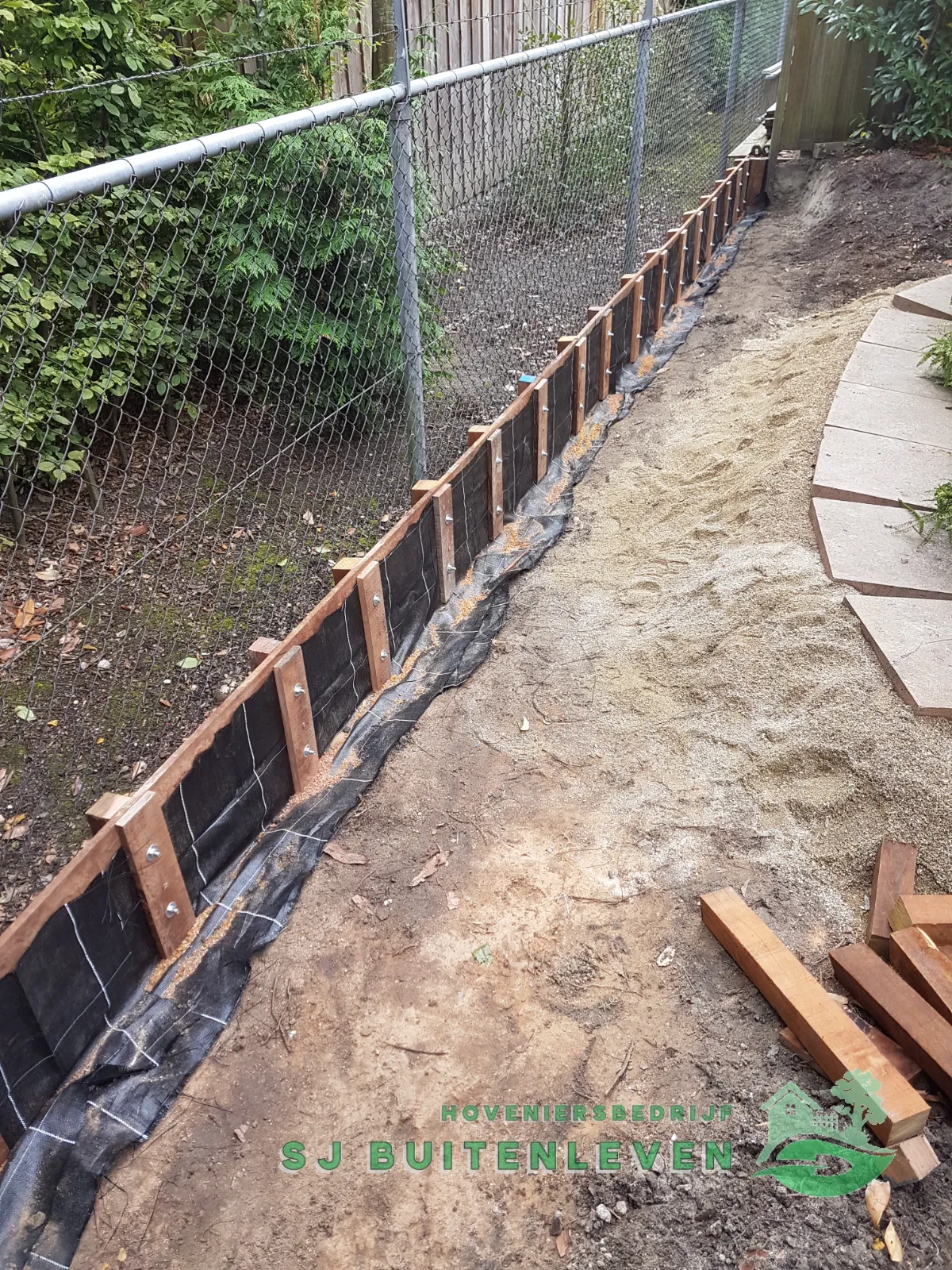 Aanleg van de houten grondkering met damwandscherm langs het gaashekwerk, in voorbereiding voor het zandpad in Nieuwe Niedorp.
